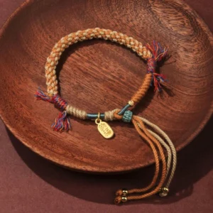 Tibetan handwoven multicolor red string luck bracelet with Fu charm flat lay