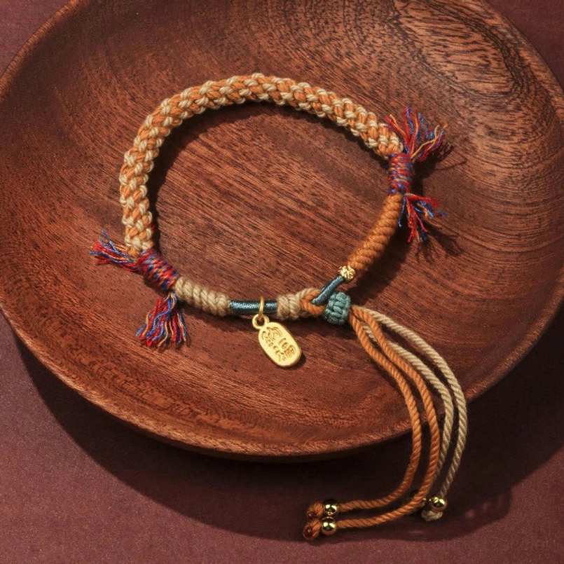 Tibetan handwoven multicolor red string luck bracelet with Fu charm flat lay