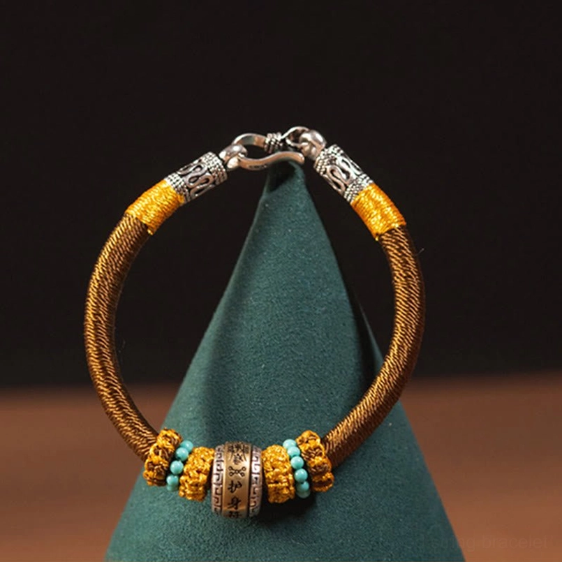 Brown Tibetan King Kong Knot bracelet close-up showing beaded metal charm and detail