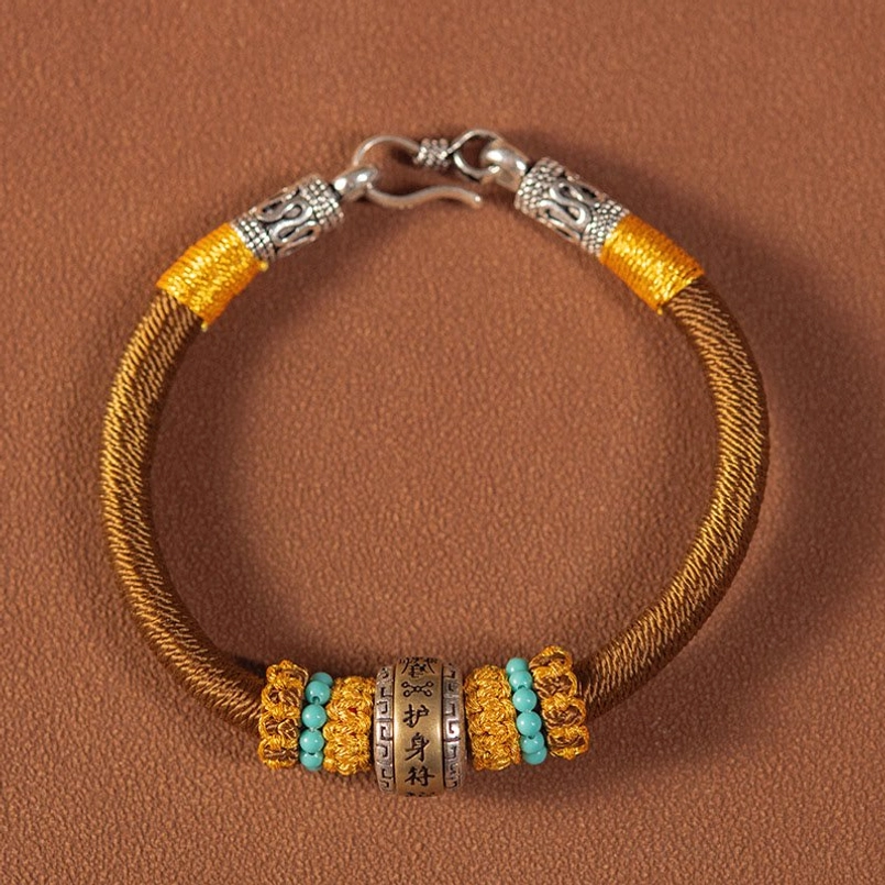 Brown woven Tibetan amulet bracelet with turquoise beads and silver clasp detail