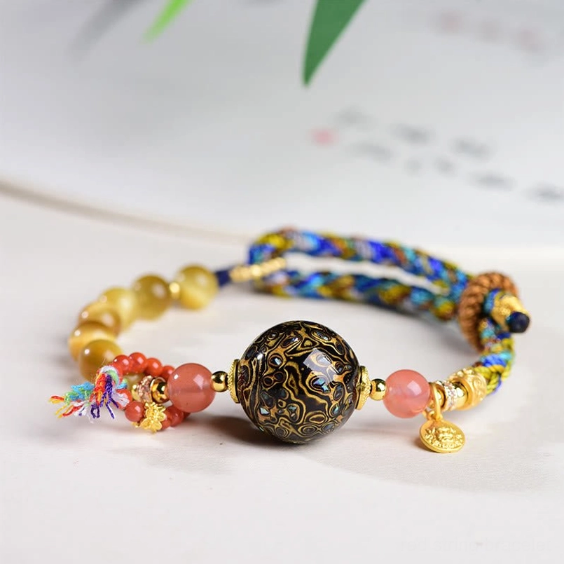 Tibetan lacquer bead tiger eye stone protection red string bracelet top view on light desk