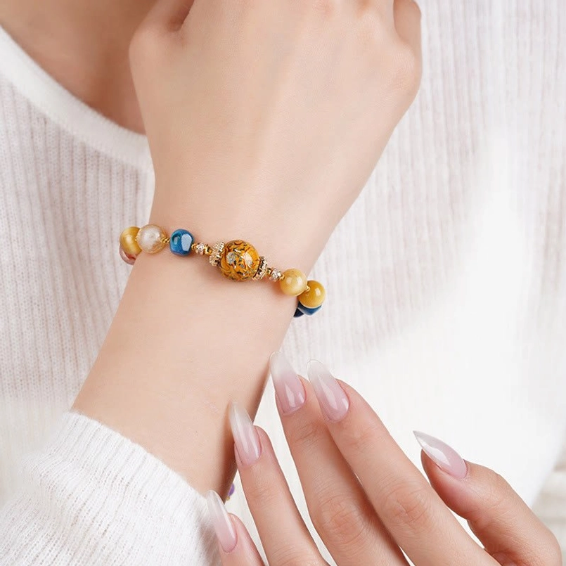 Wearing lifestyle photo of lacquer crystal bracelet on wrist with white knit sweater