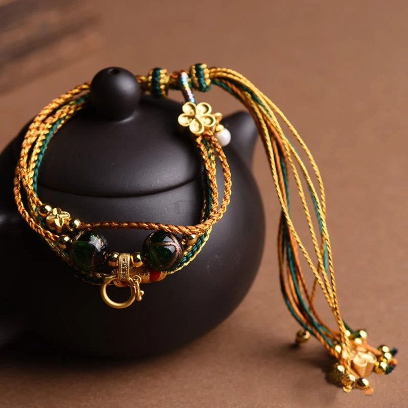 Tibetan handmade liuli glass bead healing bracelet with gold four-leaf charm and dark green beads