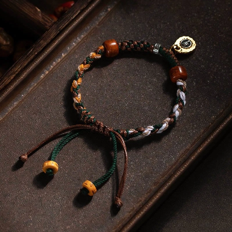 Tibetan protection red string bracelet placed on dark wooden tray