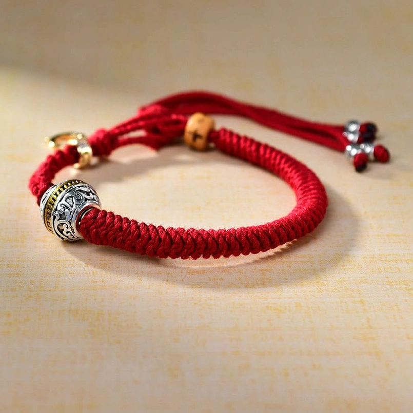 Tibetan luck red string bracelet side view with tassel pendants