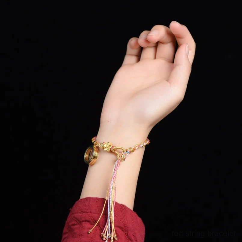 Colorful Tibetan braided lucky bracelet with gold and pastel braid featuring flower charm, pendant and tassel detail