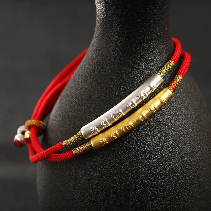 Dual-layer Tibetan mantra red string bracelets set featuring gold and silver engraved beads on black ceramic stand