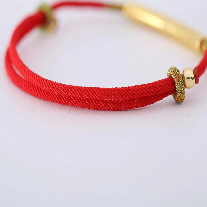 Dual-strand Tibetan mantra bracelet with gold straight tube bead and woven decorative knots on white background