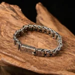 Tibetan Om Mani Padme Hum copper bracelet overhead view on dark wood surface