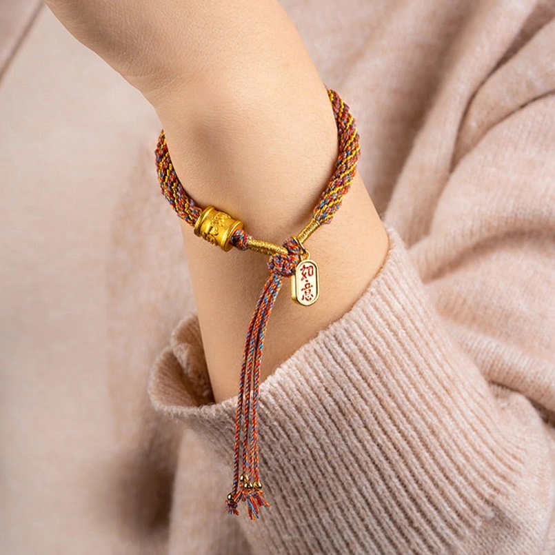 Handwoven Tibetan Om Mani Padme Hum Ruyi bracelet worn on wrist with beige knit sweater close-up