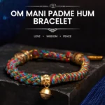 Tibetan Om Mani Padme Hum red string bracelet with Zakiram goddess charm - flat lay on dark stone