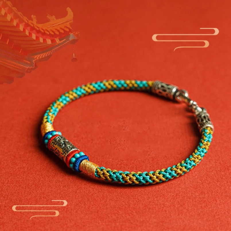 Tibetan prayer colorful string bracelet overhead view on oriental red background