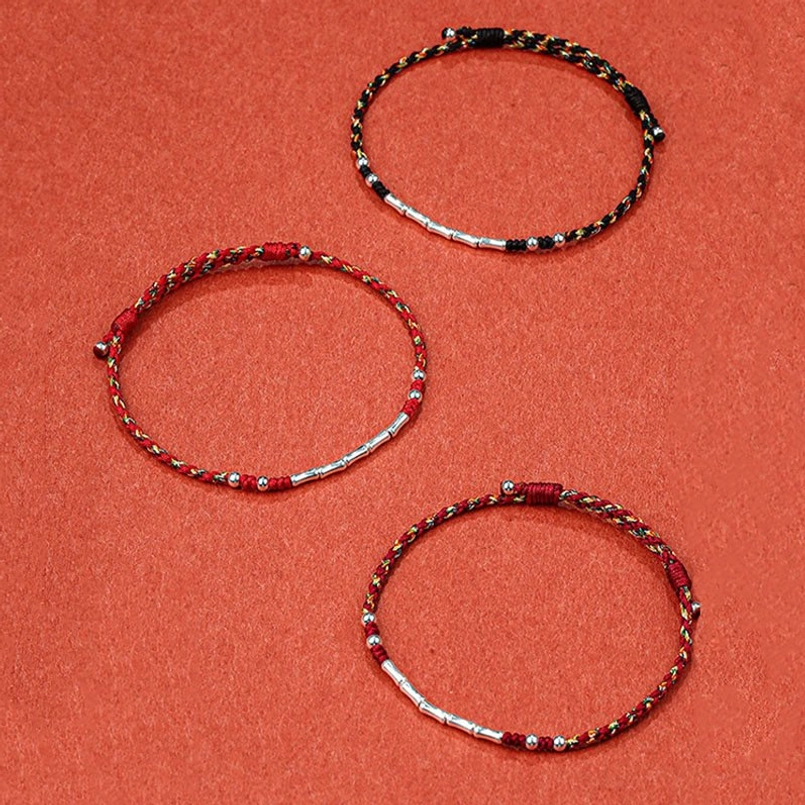 Two styles of Tibetan braided protection bracelets - black and red multicolor bamboo rope with metal accents