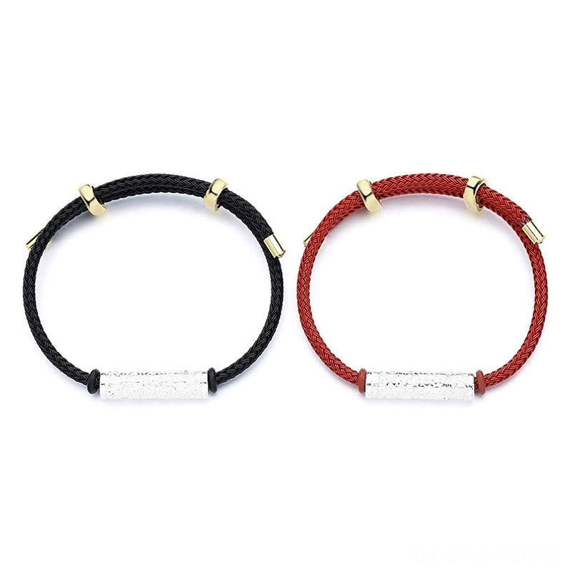 Matching red and black Tibetan string bracelets with adjustable silver sliding clasps on light wood