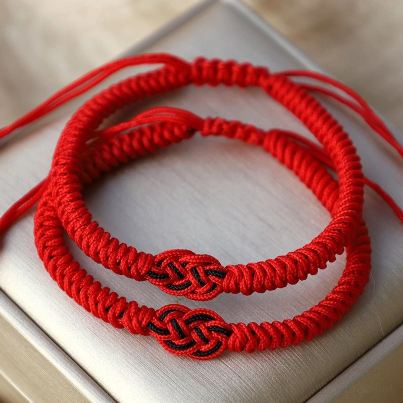 Red Tibetan protection bracelet showing pure red Chinese knot design and natural rope material