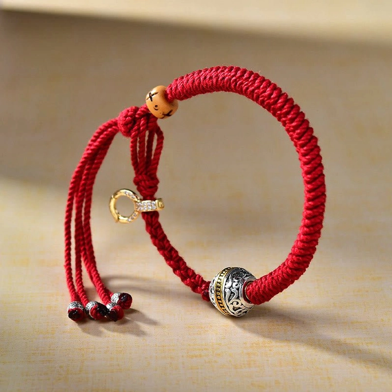 Handwoven Tibetan red rope luck bracelet side top view with wooden bead