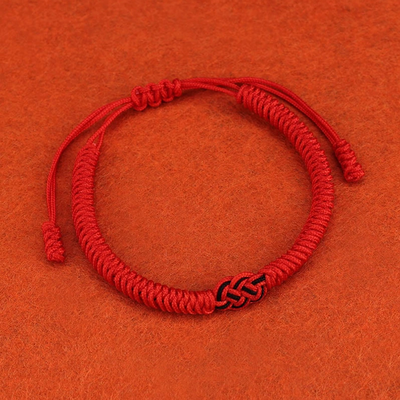Red string protection bracelet worn daily as spiritual reminder of intention and positive energy