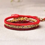 Tibetan lucky red string bracelet set three pieces stacked overhead view