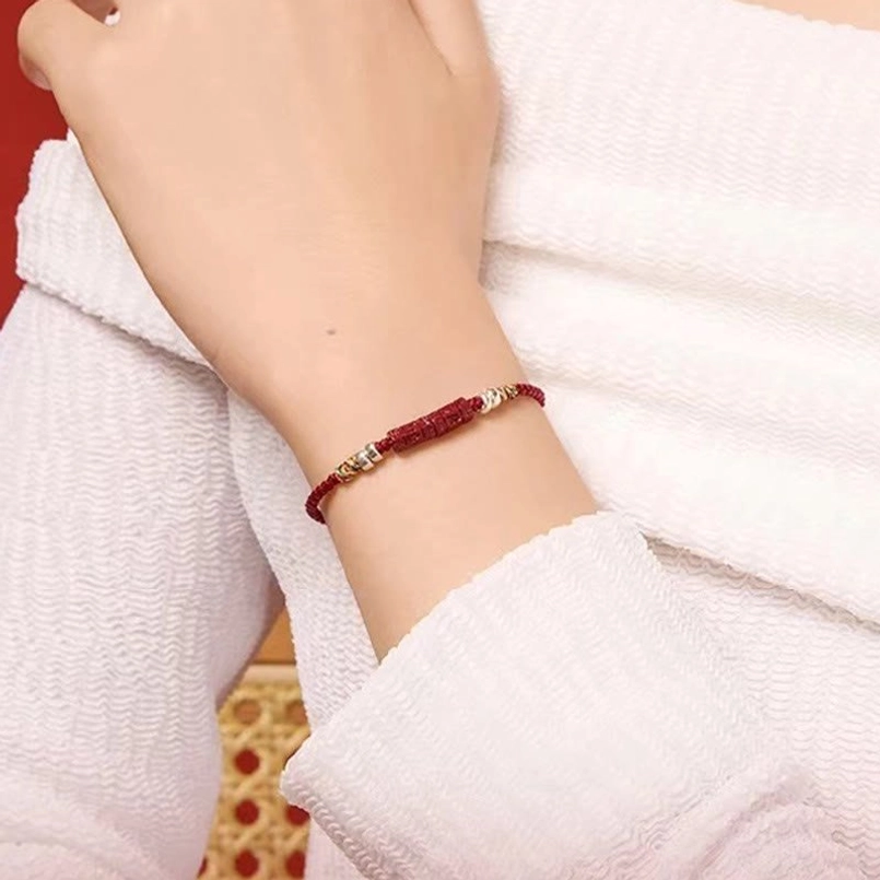 Lifestyle photo of red string protection bracelet worn on wrist with white loungewear