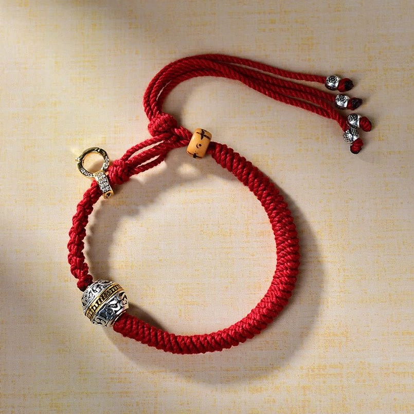 Flat lay Tibetan red string protection bracelet with silver decorative bead