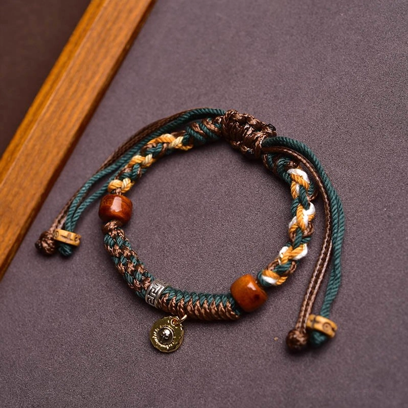 Tibetan style woven bracelet with bone beads on dark purple and wooden background