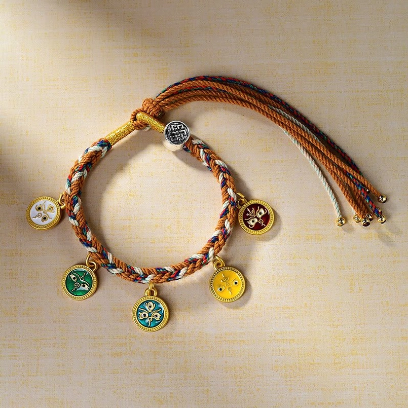 Tibetan rope bracelet with colorful enamel prosperity deities and gold tassel detail
