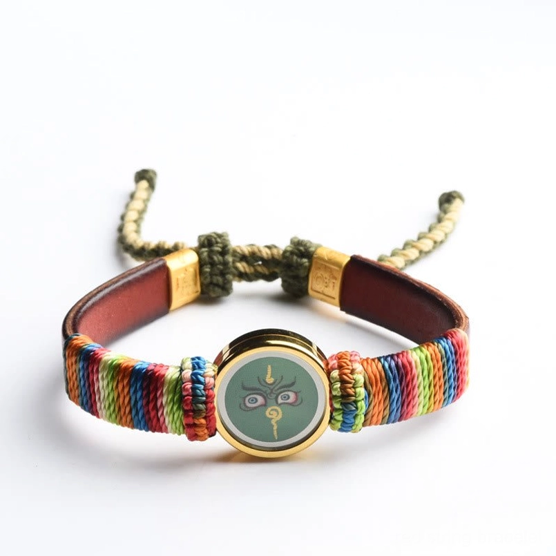 Tibetan five wealth gods bracelet flat lay with teal Buddha charm and adjustable cord