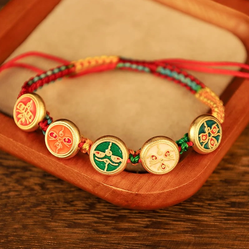 Five Gods of Wealth Tibetan bracelet overhead view displaying round enamel pendants with lucky symbols on velvet tray