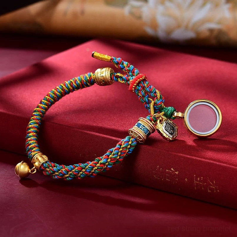 Adjustable Tibetan blessing bracelet with multiple hanging charms - light background detail