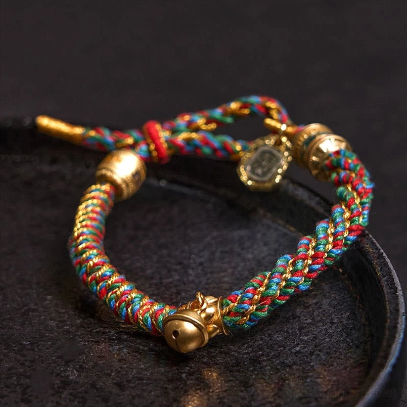 Multicolored braided Tibetan blessing bracelet with gold bell charm and dual pendants - close-up detail