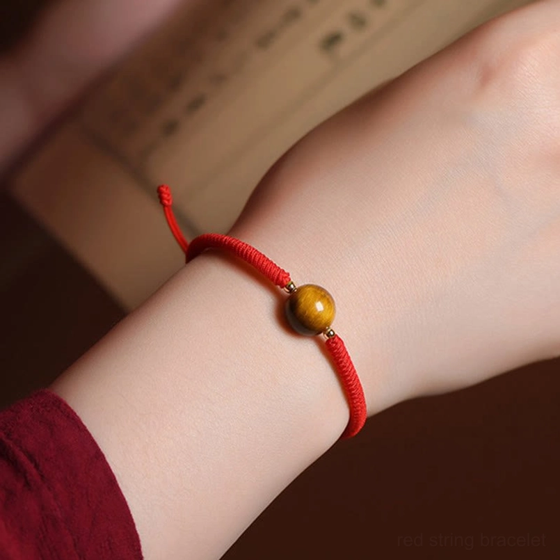 Tiger eye red string bracelet worn on wrist showing protective talisman style