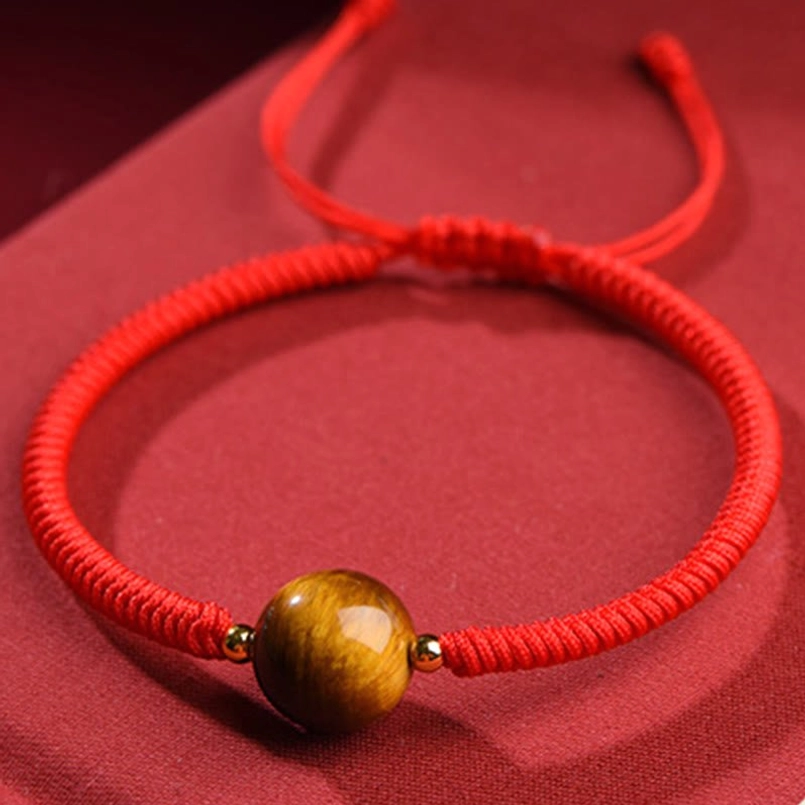 Handmade tiger eye bracelet full flat lay front view showing braided red rope design