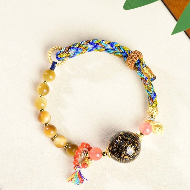 Tiger eye stone beaded woven red string bracelet with colorful tassel pendant close up