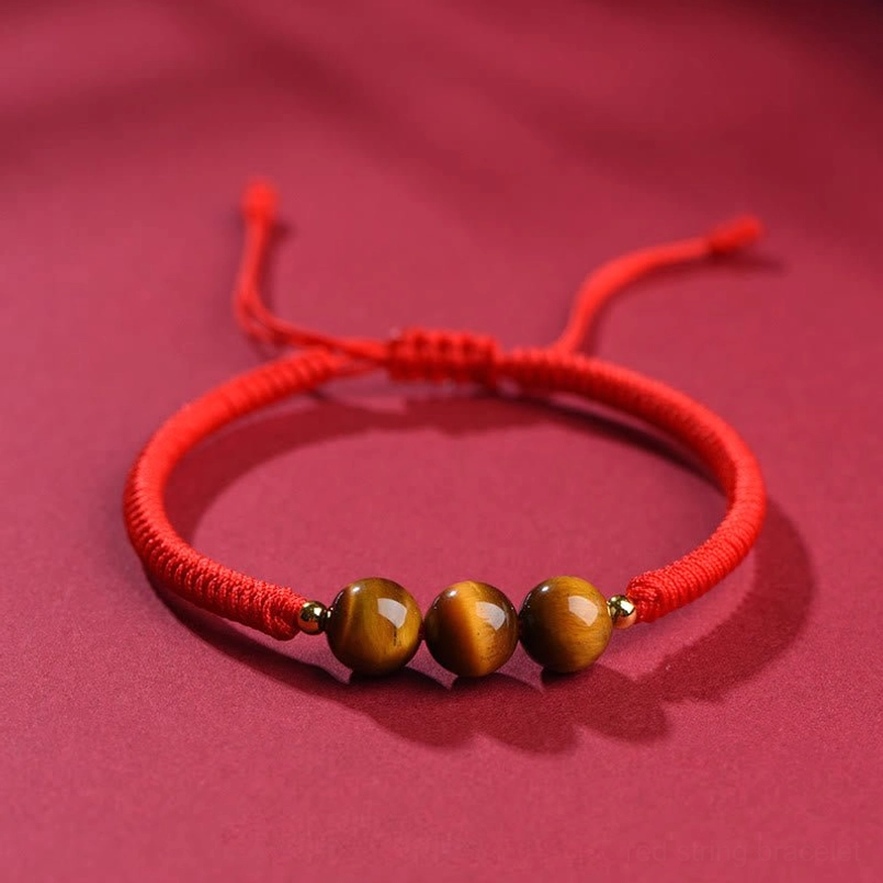 Triple tiger eye beads bracelet with 8mm beads and gold spacers on red fabric