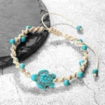 Turquoise turtle braided red string protection bracelet on black slate coaster