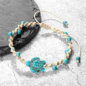 Turquoise turtle braided red string protection bracelet on black slate coaster