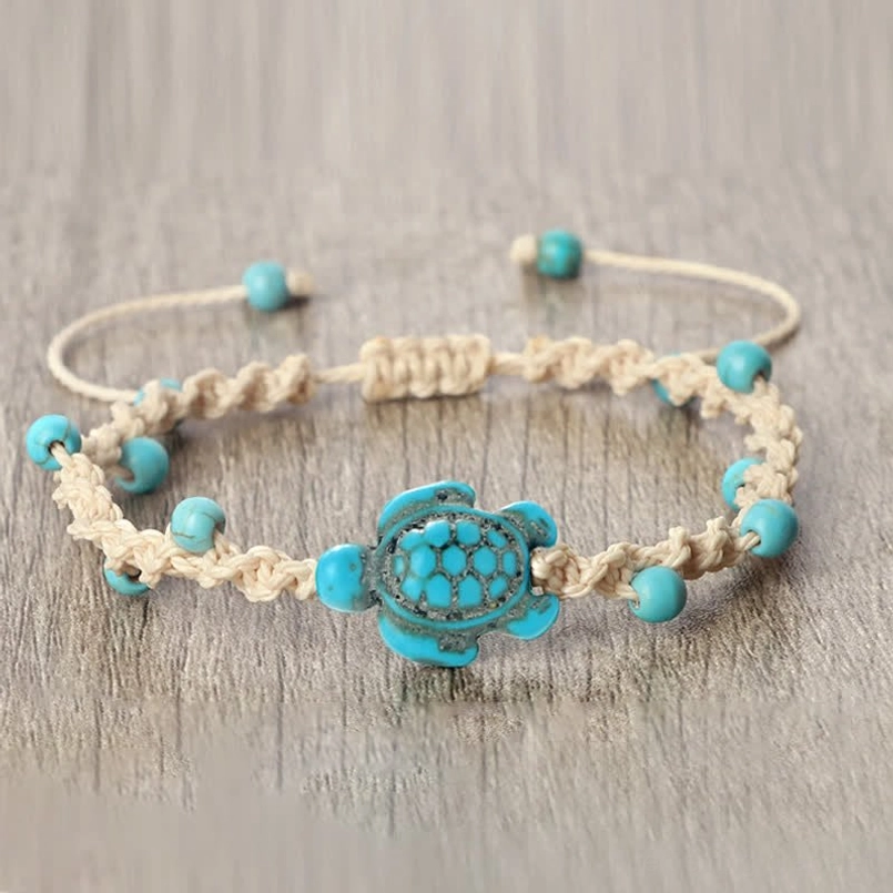 Adjustable turquoise turtle protection bracelet on wooden surface
