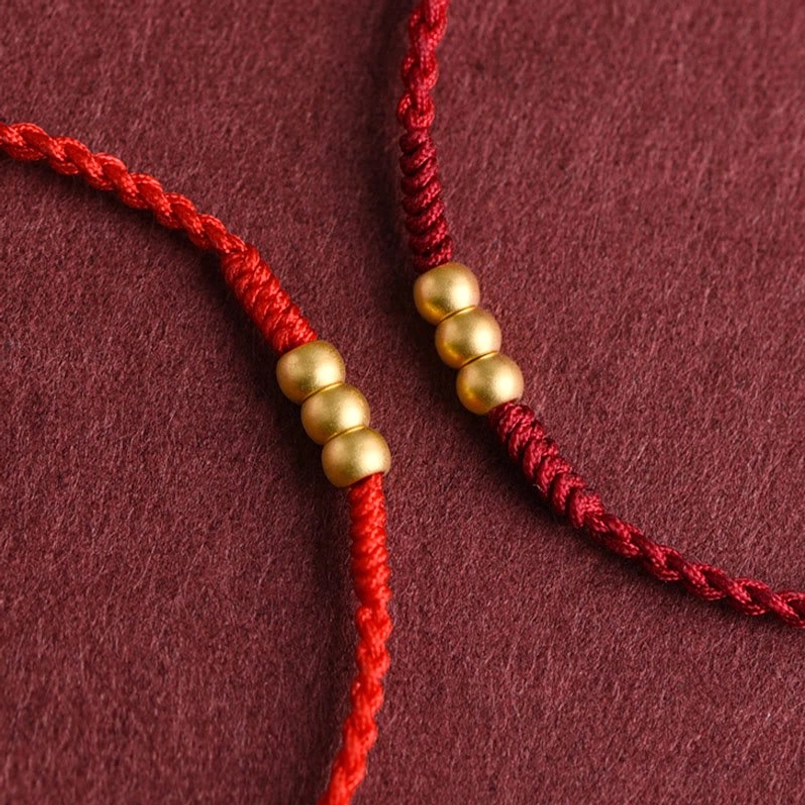 Two red string bracelets with different red shade comparison top view