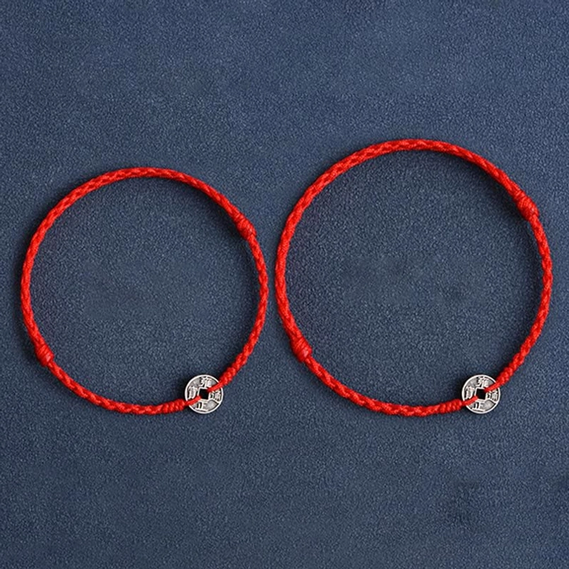 Pair of matching Five Emperor Coins red string bracelets with identical silver coin charms overhead view