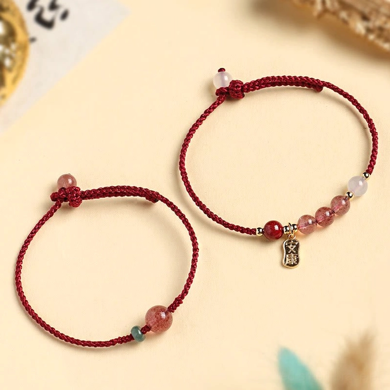Two style options of strawberry quartz red string bracelets laid flat