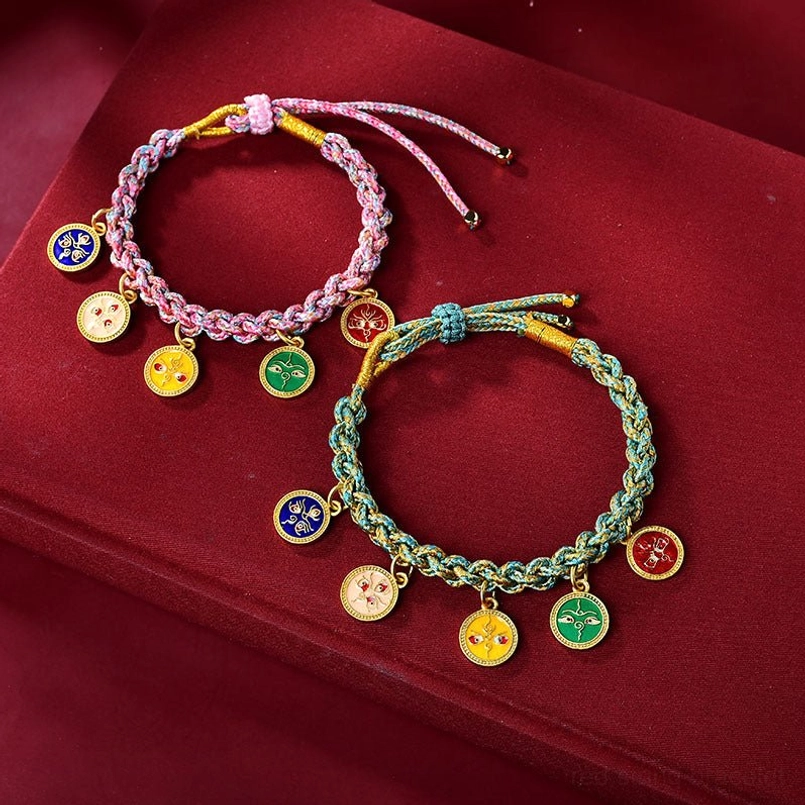 Flat lay of two Tibetan prosperity lucky bracelets pink and teal on red velvet background