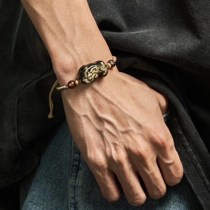 Gold Sheen Obsidian PiXiu wealth bracelet worn on left wrist showing daily wear styling on denim and dark clothing