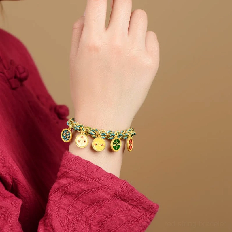 Five gods of wealth bracelet worn on wrist with ethnic red clothing background
