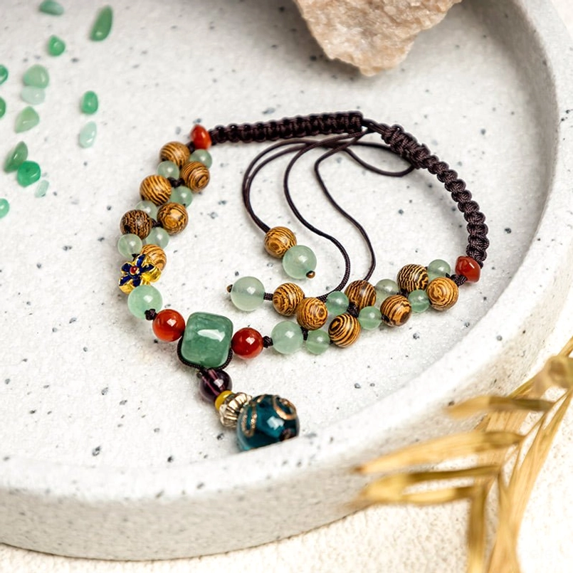 Green aventurine wenge wood beaded ankle bracelet on ceramic tray showing mixed stone details