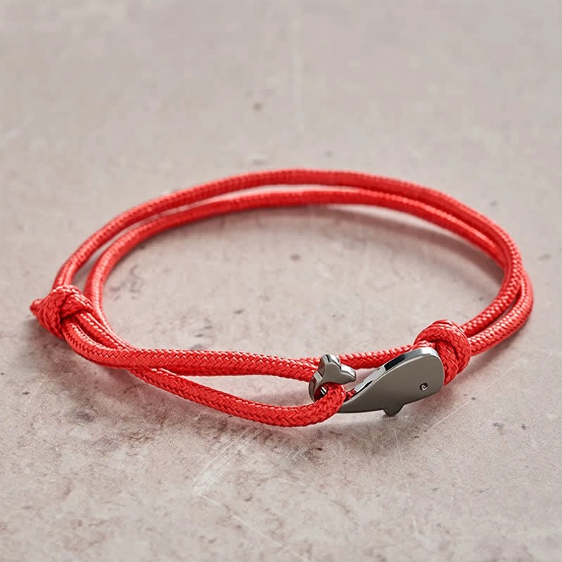 Red string whale bracelet showing braided rope texture and hand-tied knots detail