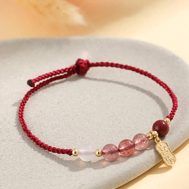 Side view of strawberry quartz white agate red string bracelet on neutral background