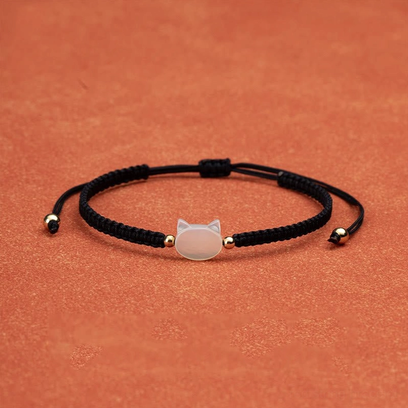 White shell cat charm black string bracelet side angle detail shot