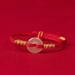 White chalcedony peace buckle red string bracelet with gold twisted knots, flat front view