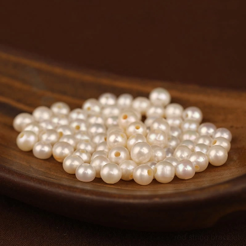 Smooth lustrous white freshwater pearls displayed on wooden plate background