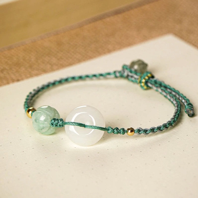 Jade peace buckle luck bracelet flat lay with white jade buckle and green pumpkin bead accent